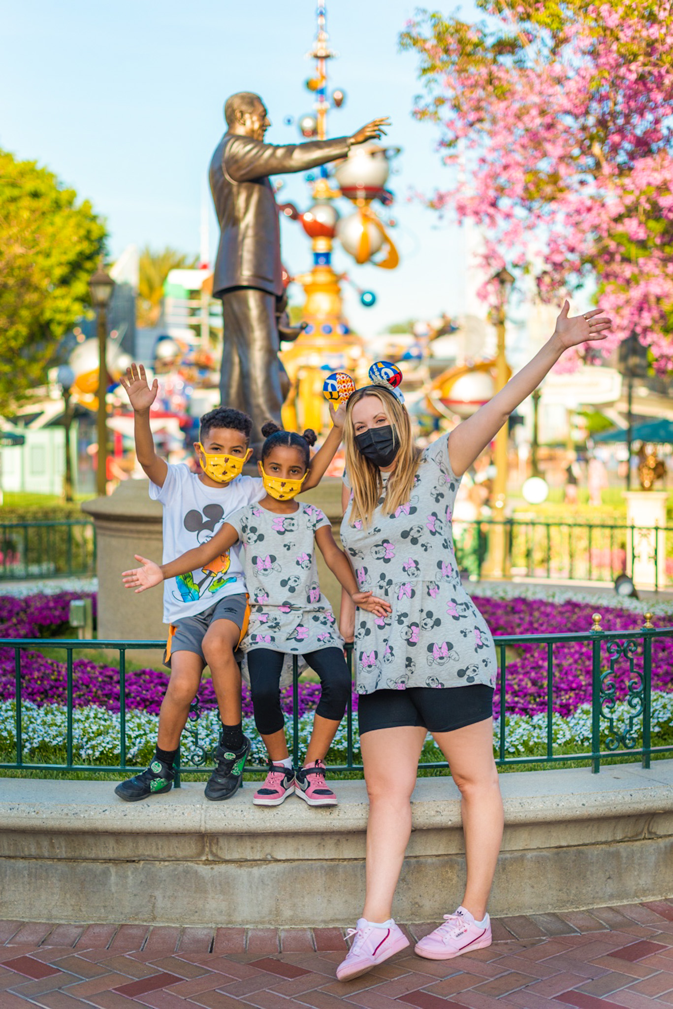 disneyland reopening | Disneyland Reopening by popular LA lifestyle blog, Posh in Progress: image of a mom and her two kids wearing Mickey and Minnie Mouse clothing and standing in front of the Walt Disney statue at Disneyland. 