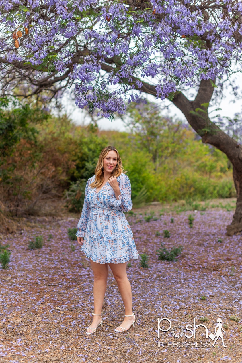 floral backless dress 3 | Backless Dresses by popular LA fashion blog, Posh in Progress: image of a woman standing under a jacaranda tree and wearing a white floral print dress with white heel sandals. 