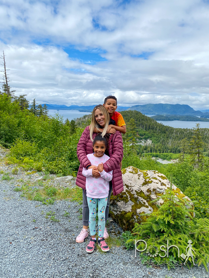 Things to do in Sitka Alaska by popular LA travel blog, Posh in Progress: image of a mom and her young son and daughter standing together at the top of Harbor Mountain. 